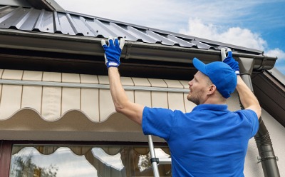 A serviceman performing Gutter Installation in Peoria IL